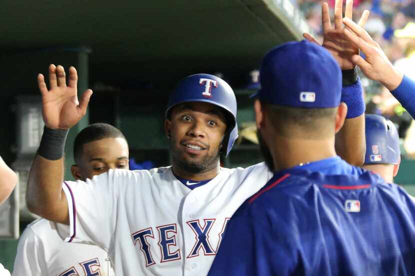 Texas Rangers shortstop Elvis Andrus (1) talks with pitcher Martin Perez, right, in the...