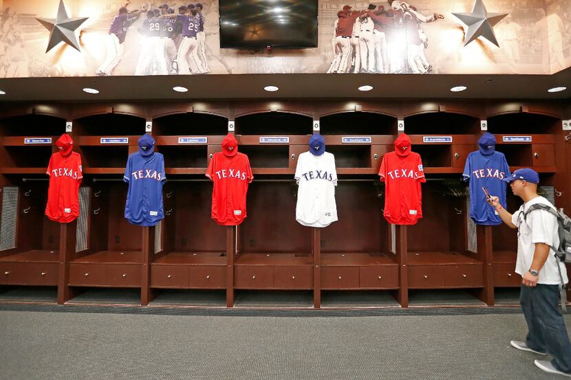Rangers fan Nathanal Baez uses his cell phone to photograph uniforms and lockers of Rangers...