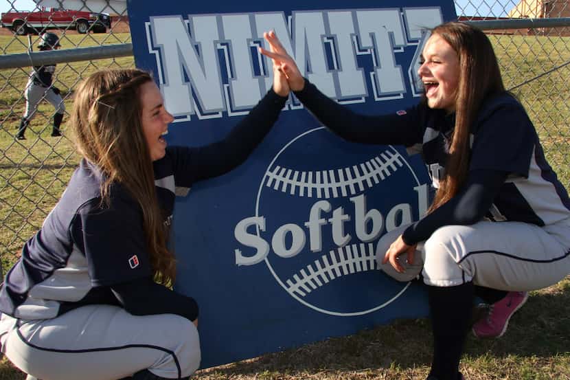 Jordan Cox(6), left, and Alli Jones (11) share a "High Five" as they loosen up prior to warm...