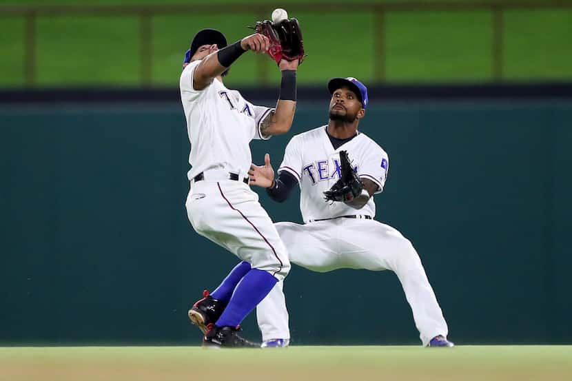 ARLINGTON, TX - JULY 23:  (L-R) Rougned Odor #12 of the Texas Rangers tries to field a fly...