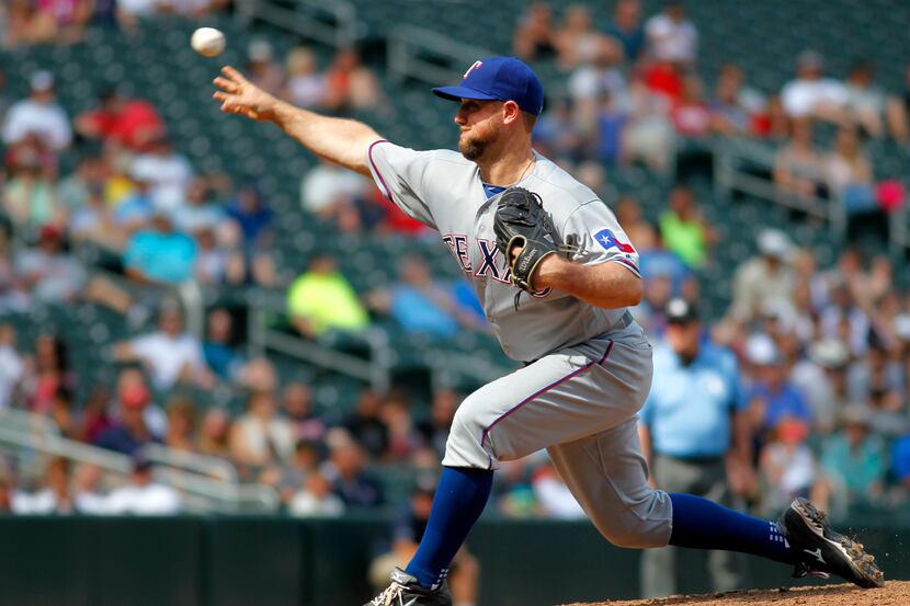 Texas Rangers catcher Bryan Holaday pitches in the eighth inning against the Minnesota Twins...