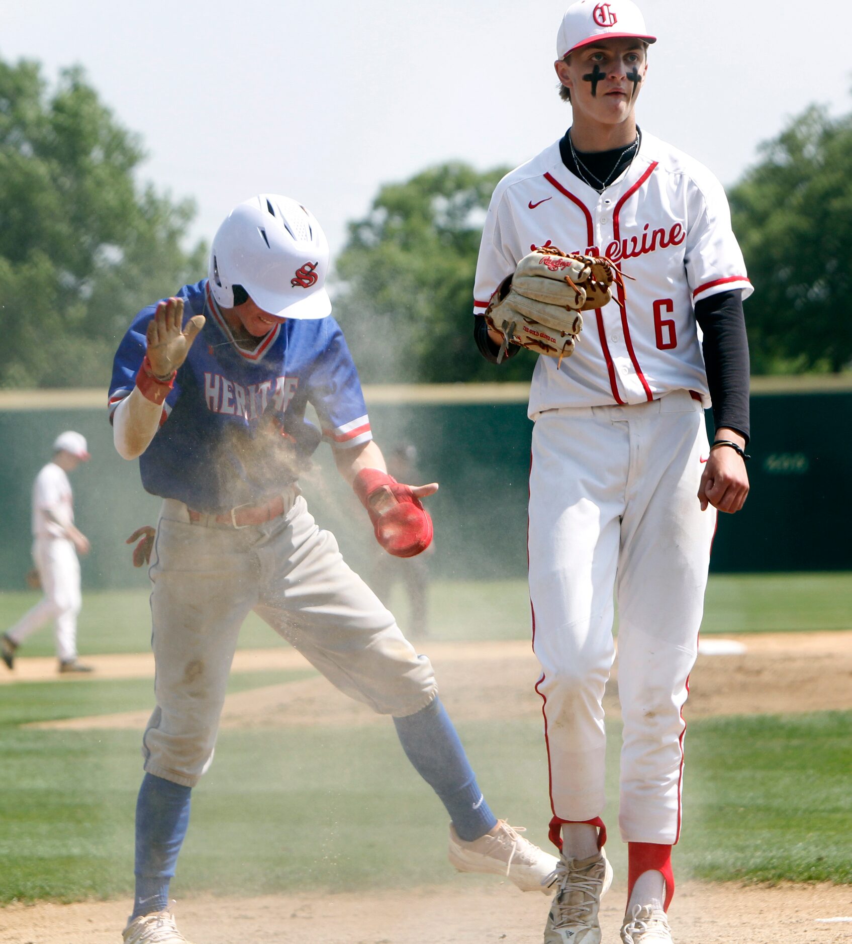 Midlothian Heritage base runner Hunter Trojacek (17), left, celebrates after scoring on a...