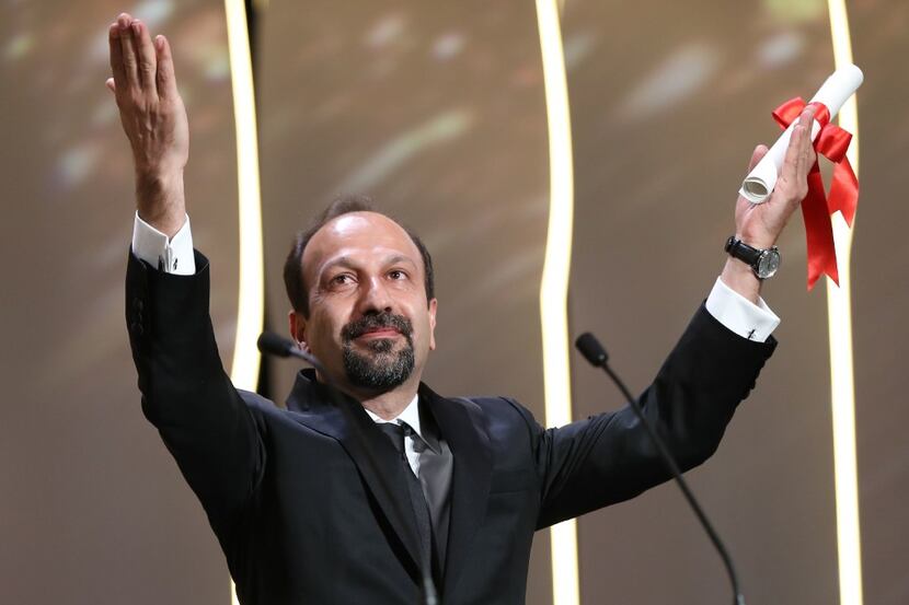 Iranian director Asghar Farhadi celebrates onstage after being awarded the Best Screenplay...
