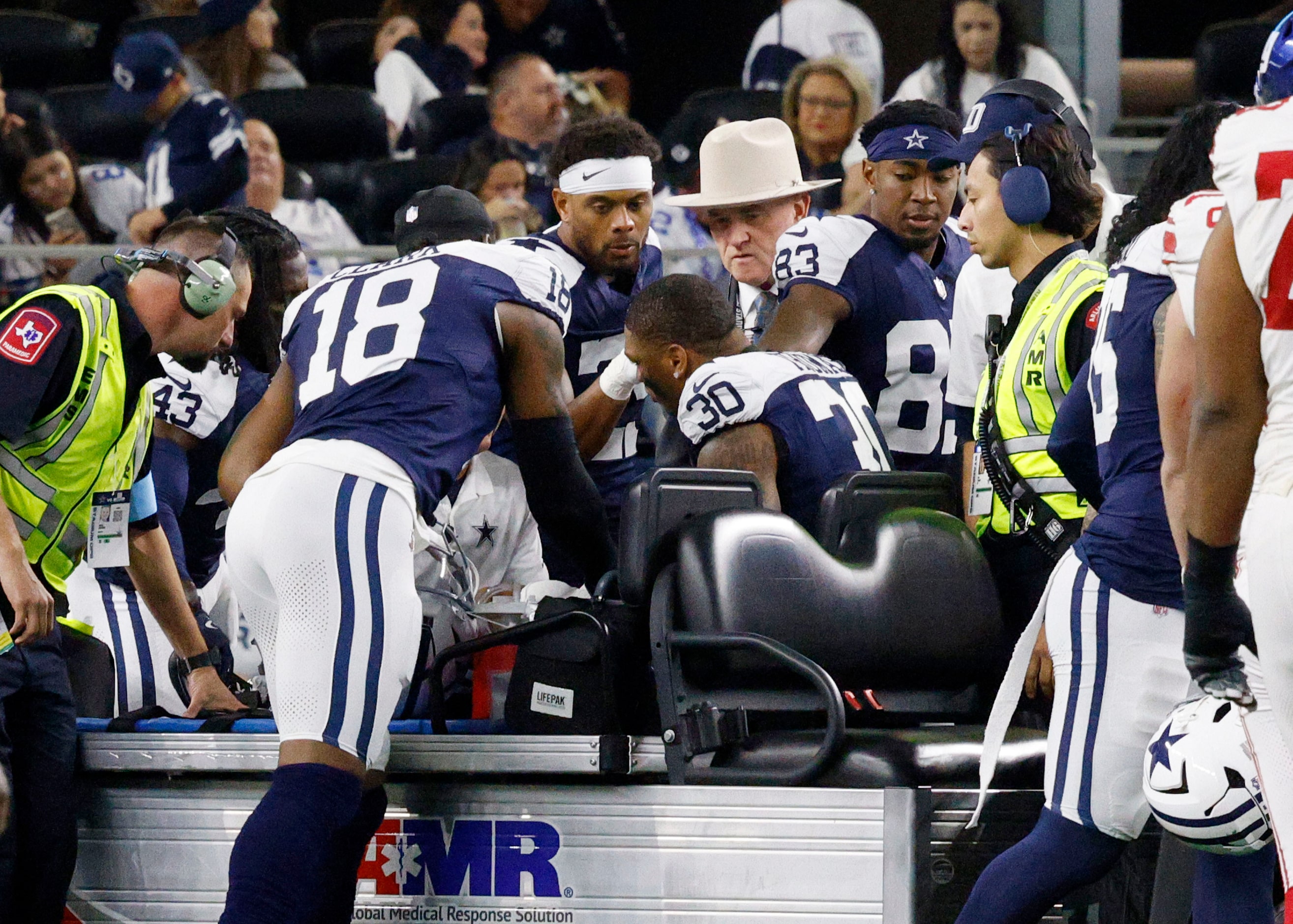 Dallas Cowboys safety Juanyeh Thomas (30) leaves by a cart as his teammates look on after he...