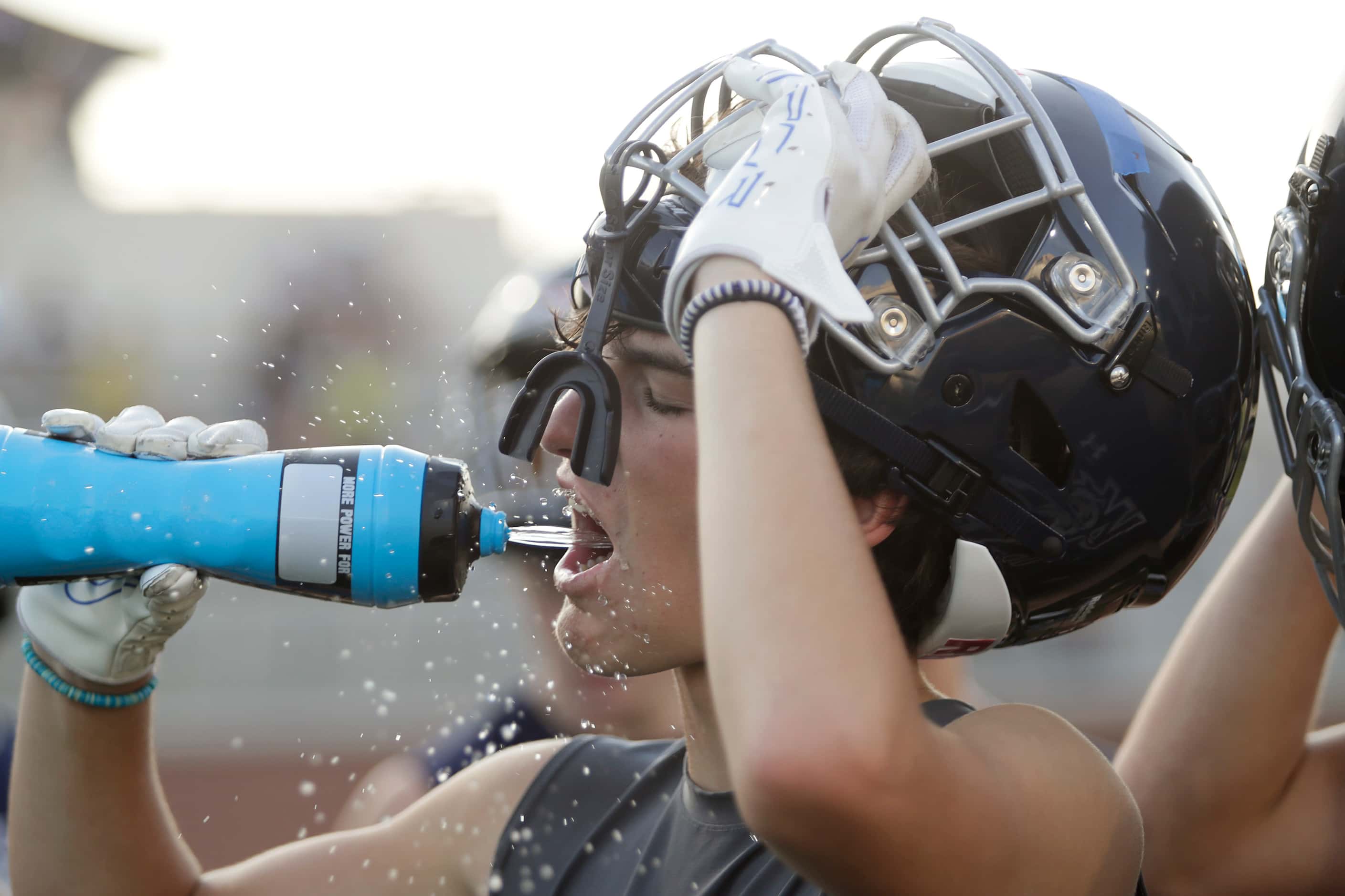 Wide Receiver Cade Carter, 15, takes a drink during the first water break as Walnut Grove...