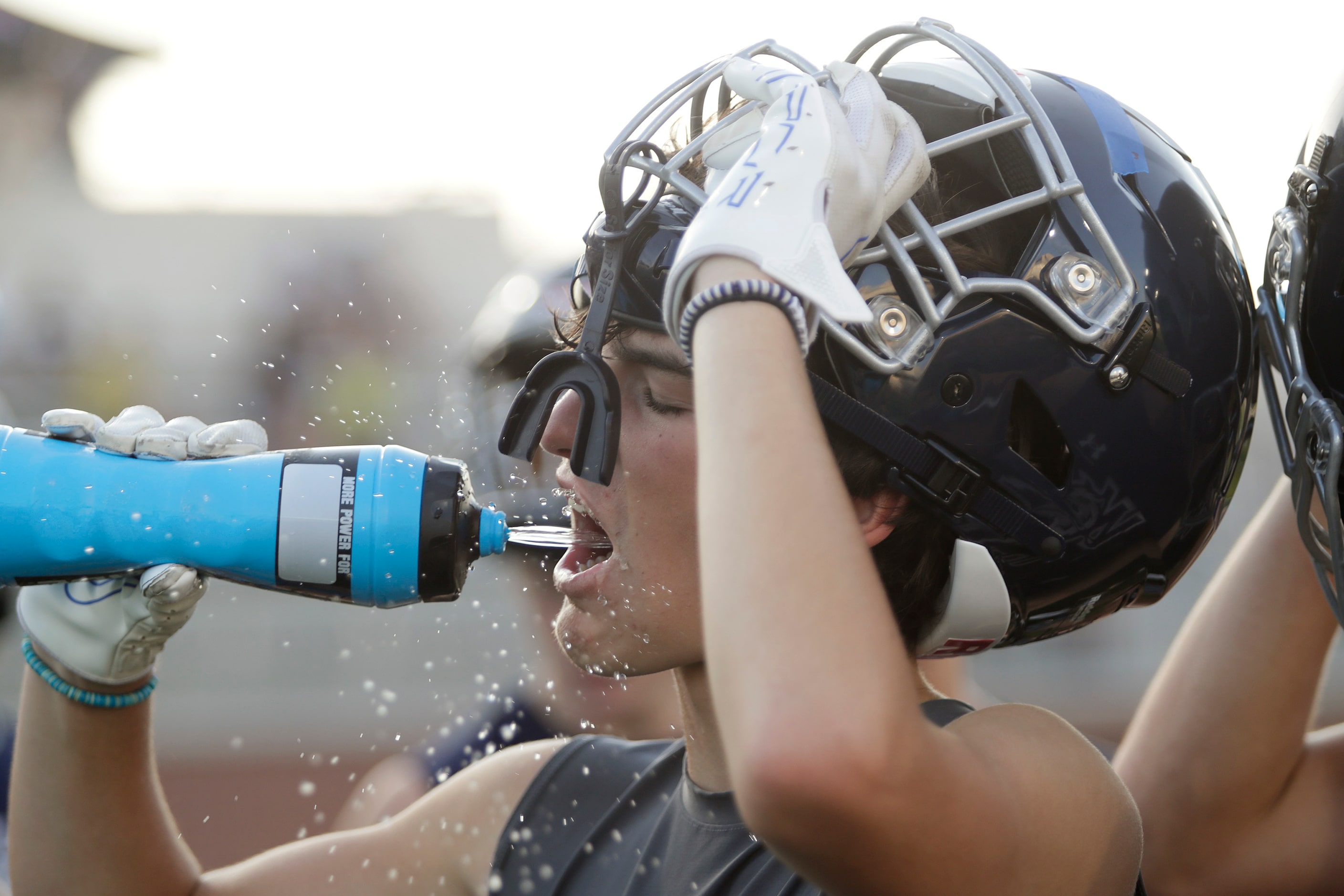 Wide Receiver Cade Carter, 15, takes a drink during the first water break as Walnut Grove...