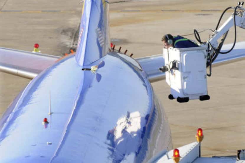 An investigator looked closely at a football-size hole in the roof of a Southwest Airlines...
