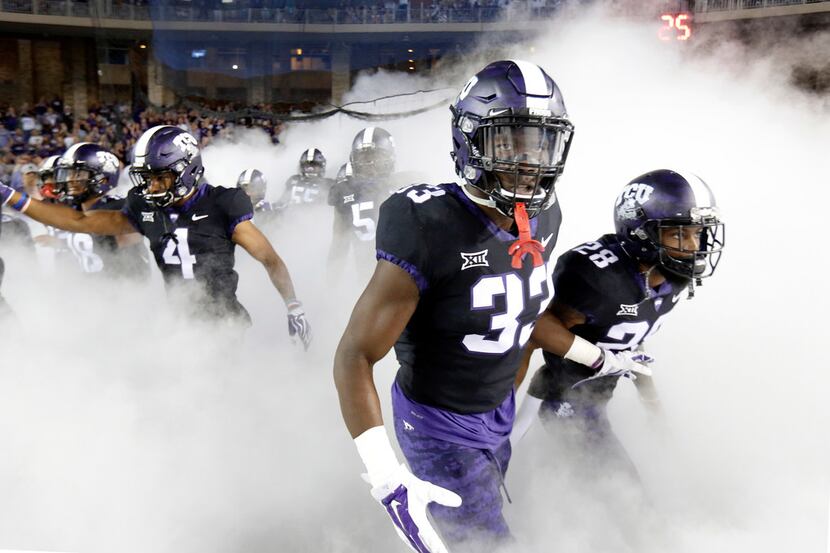 TCU Horned Frogs running back Sewo Olonilua (33) and his teammates race through the fog as...