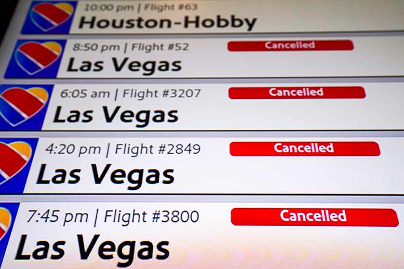 Flight status boards show canceled Southwest airlines flights at Dallas Love Field on...