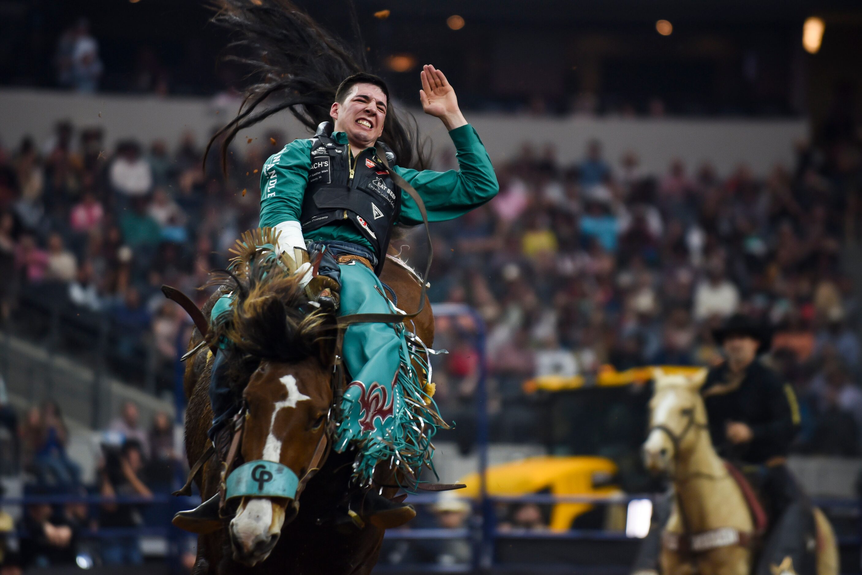 Jesse Pope attempts to stay on his horse as a part of the Bareback Bronc event during the...