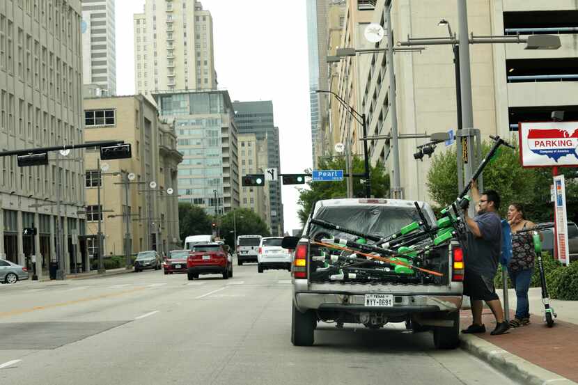 Rental scooters get loaded into a truck in Dallas, Texas, on Sep. 1, 2020. (Jason...