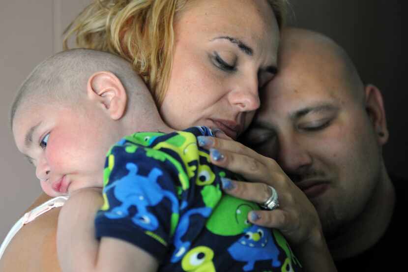 Christine Swidorsky holds her son, Logan Stevenson, 2, with her husband-to-be and Logan's...