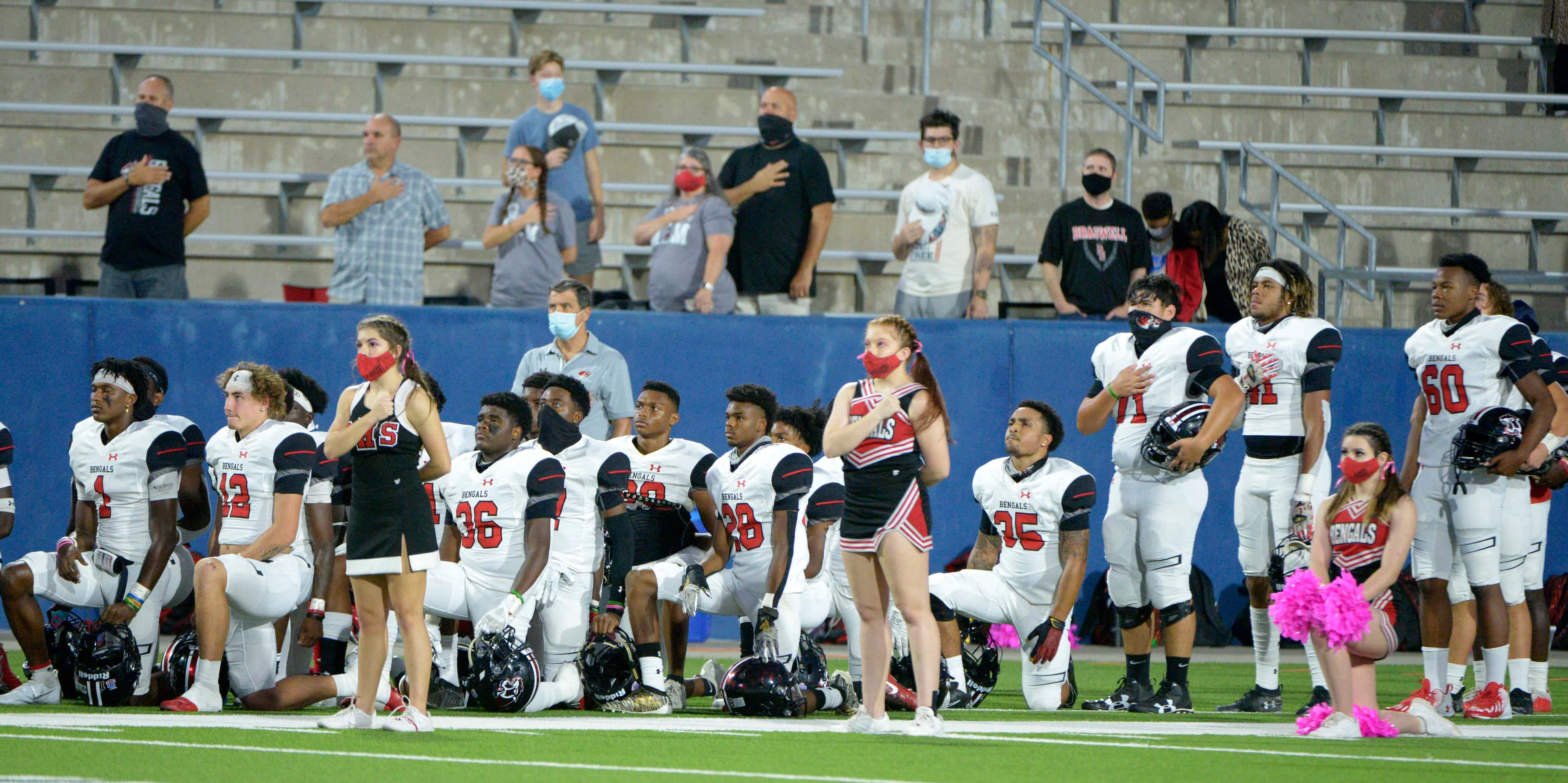 Denton Braswell players and cheerleaders during the National Anthem before a high school...