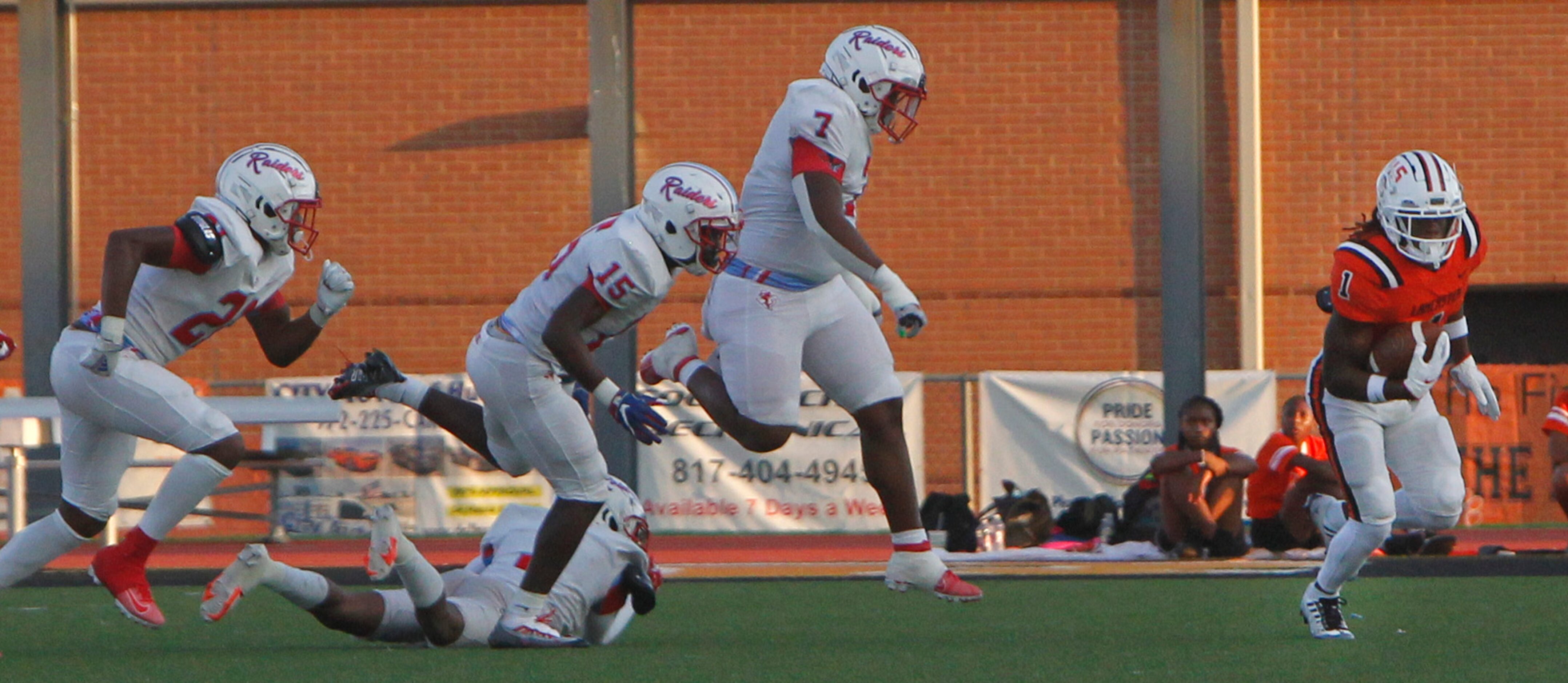 Lancaster running back Kyson Brown (1), right, avoids the pursuit from Dallas Skyline...