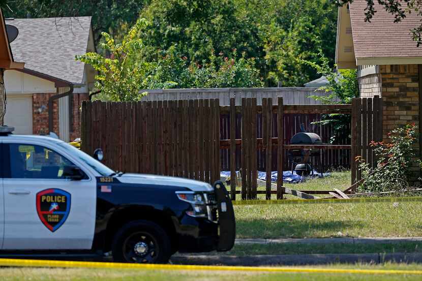 A Plano police officer secures the area of the crime scene on West Spring Creek Parkway in...