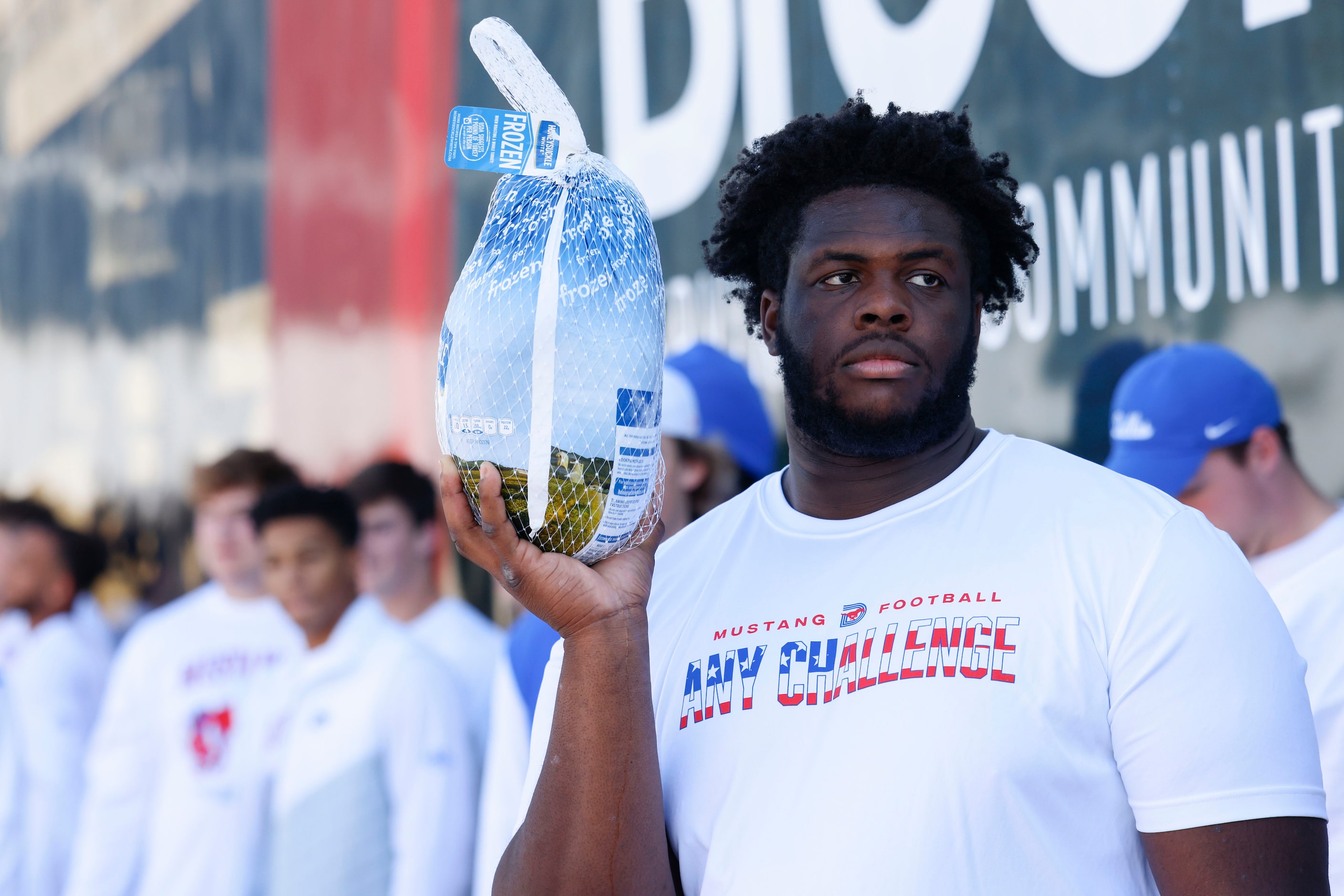 Southern Methodist University’s Anthony Booker Jr. waits to hand out a whole turkey, on...