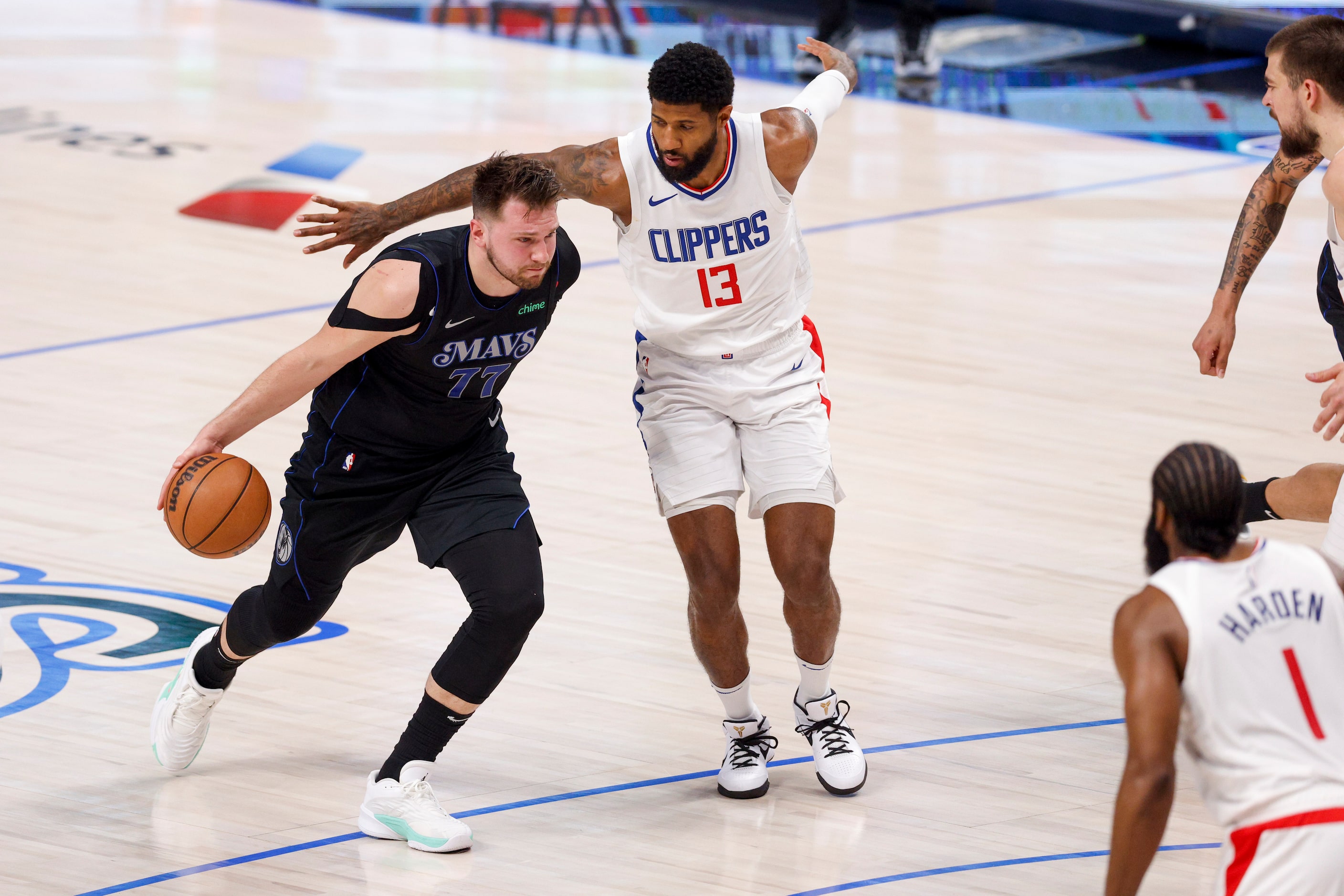 Dallas Mavericks guard Luka Doncic (77) dribbles past LA Clippers forward Paul George (13)...