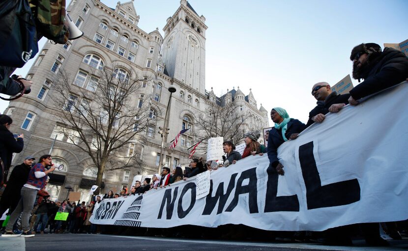 Protesters march along Pennsylvania Avenue past the Trump International Hotel during a rally...