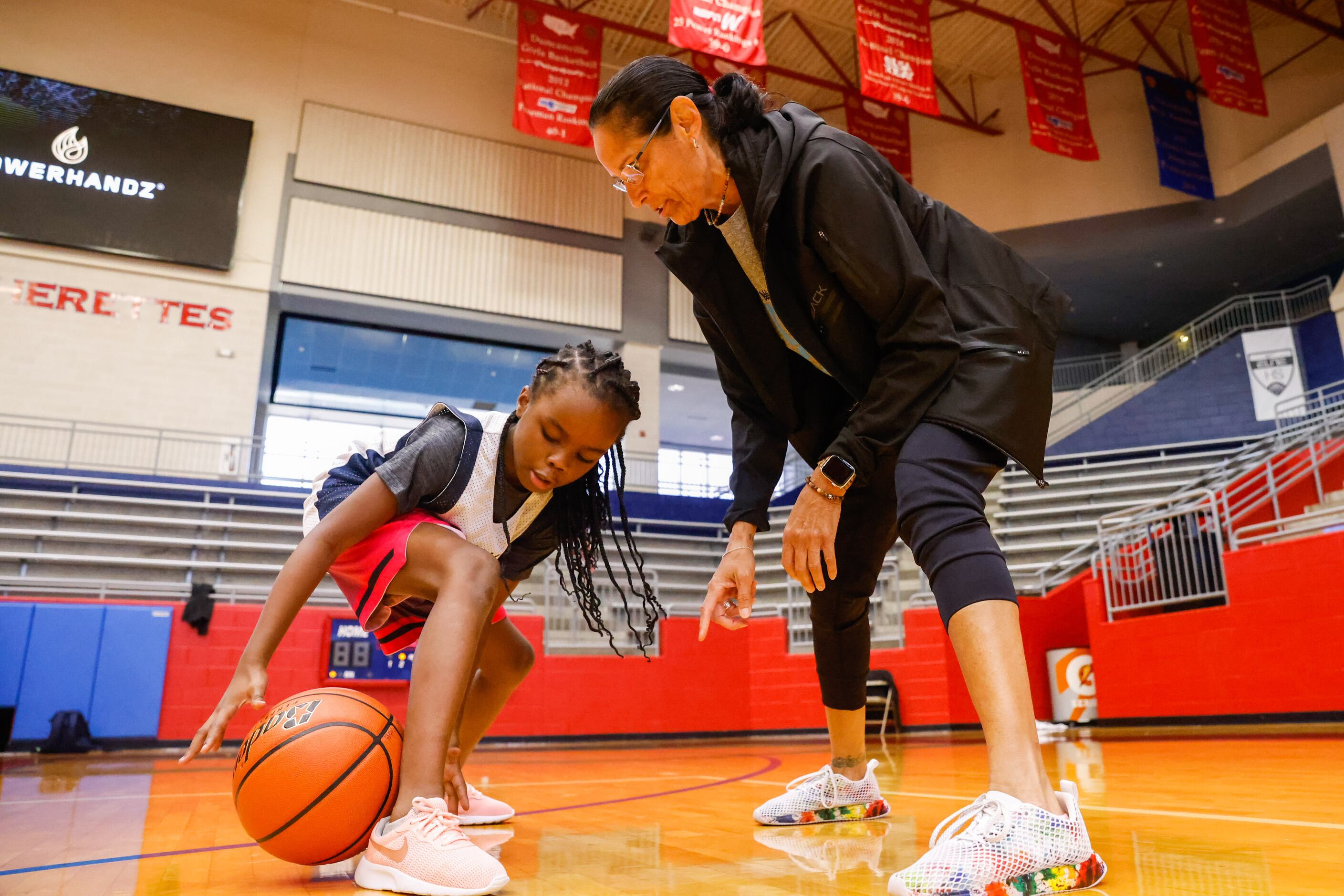 Christina Camacho helps Asia Reed, 6, during the EmPOWERment camp with former Duncanville...