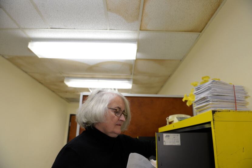 Executive Director Mary Rakowitz looks through the files of previous clients at Oak Cliff...
