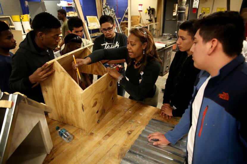 Construction technology teacher Tamara Gurnell gives instruction to students as they...