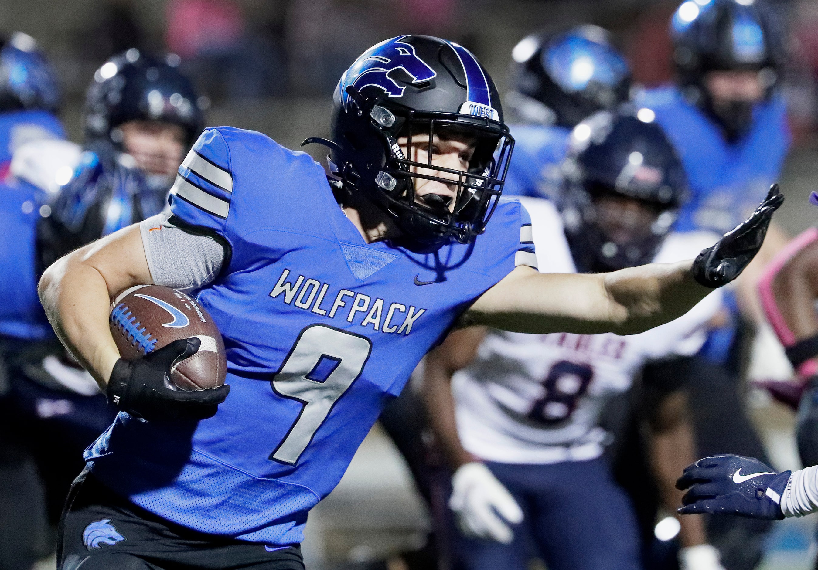 Plano West High School wide receiver Sebastian Langley (9) prepares to stiff arm as he runs...