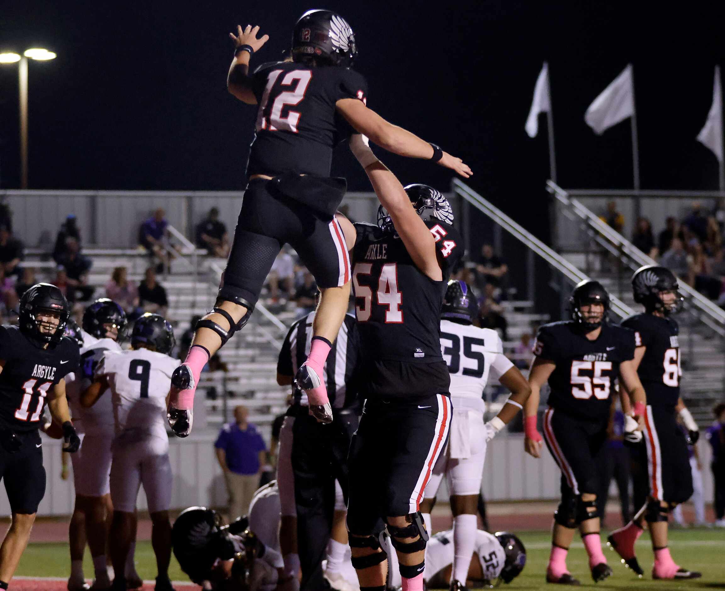 Argyle quarterback John Gailey (12) is hoisted in the air by lineman Wes Tucker (54) after...