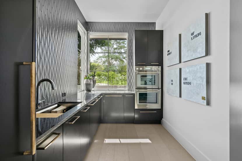 Black cabinets and countertops create a sleek feel in this butler's pantry.