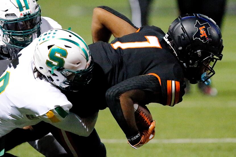 Lancaster High School wide receiver Phaizon Wilson (7) is tackled by Newman Smith High...