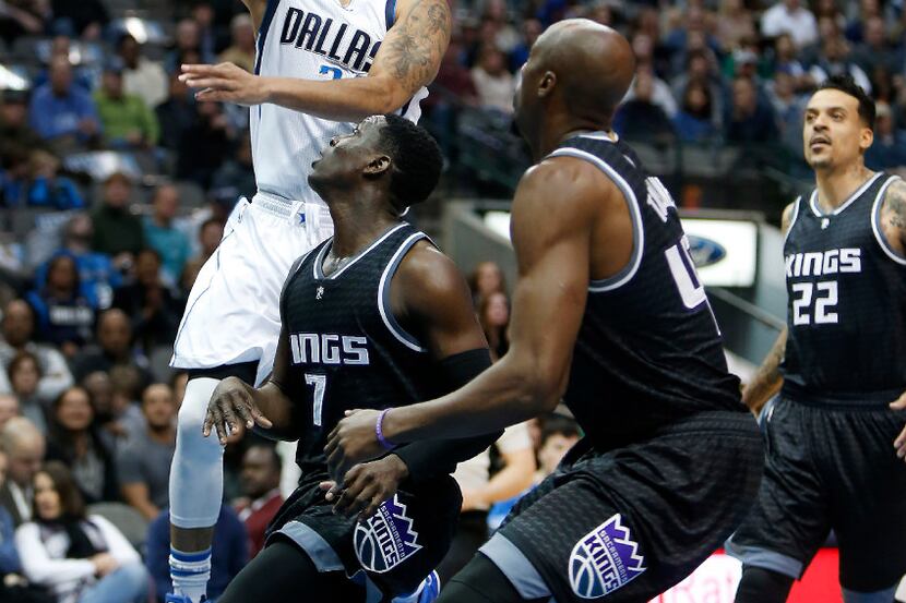 Dallas Mavericks guard Devin Harris, left, drives for a layup past Sacramento Kings guard...
