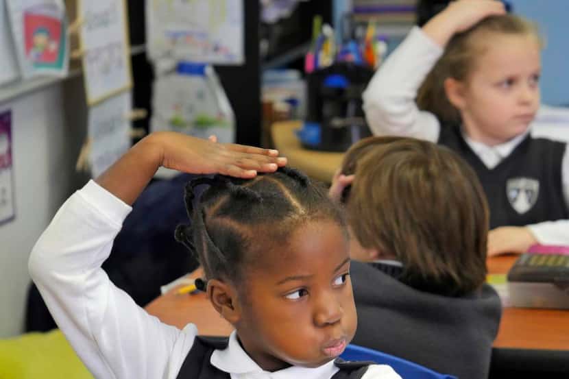 
Uplift Grand Preparatory first-grade scholar Mefowe Kue, 6, patted her head in agreement...