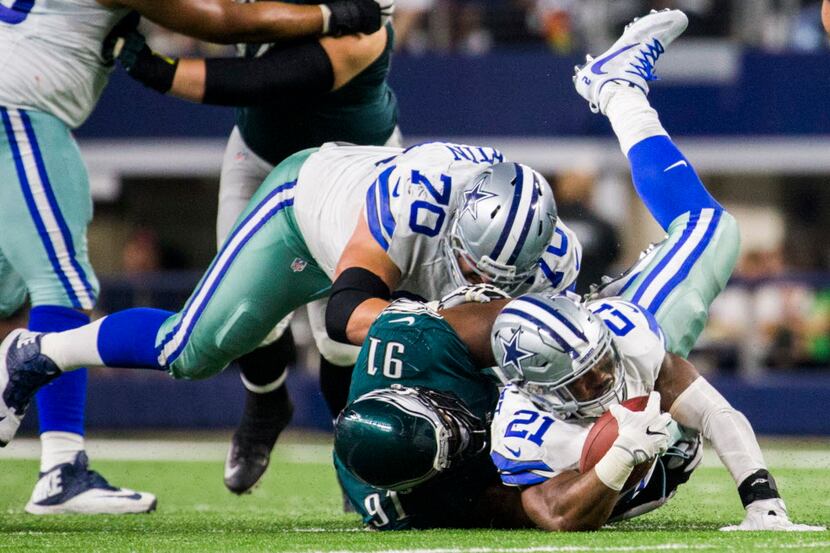 Dallas Cowboys running back Ezekiel Elliott (21) is tackled by Philadelphia Eagles defensive...