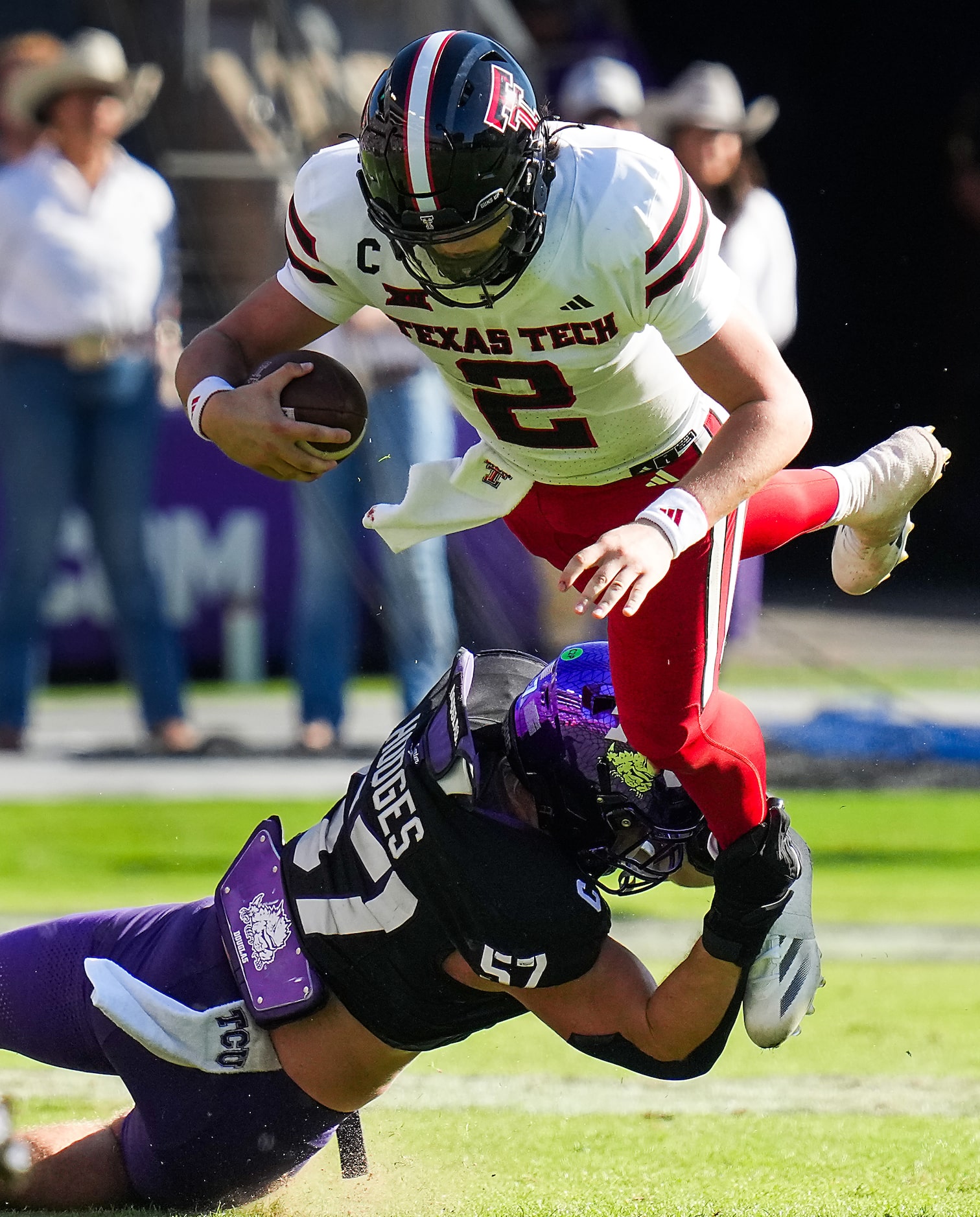 Texas Tech quarterback Behren Morton (2) is tripped up by TCU linebacker Johnny Hodges (57)...