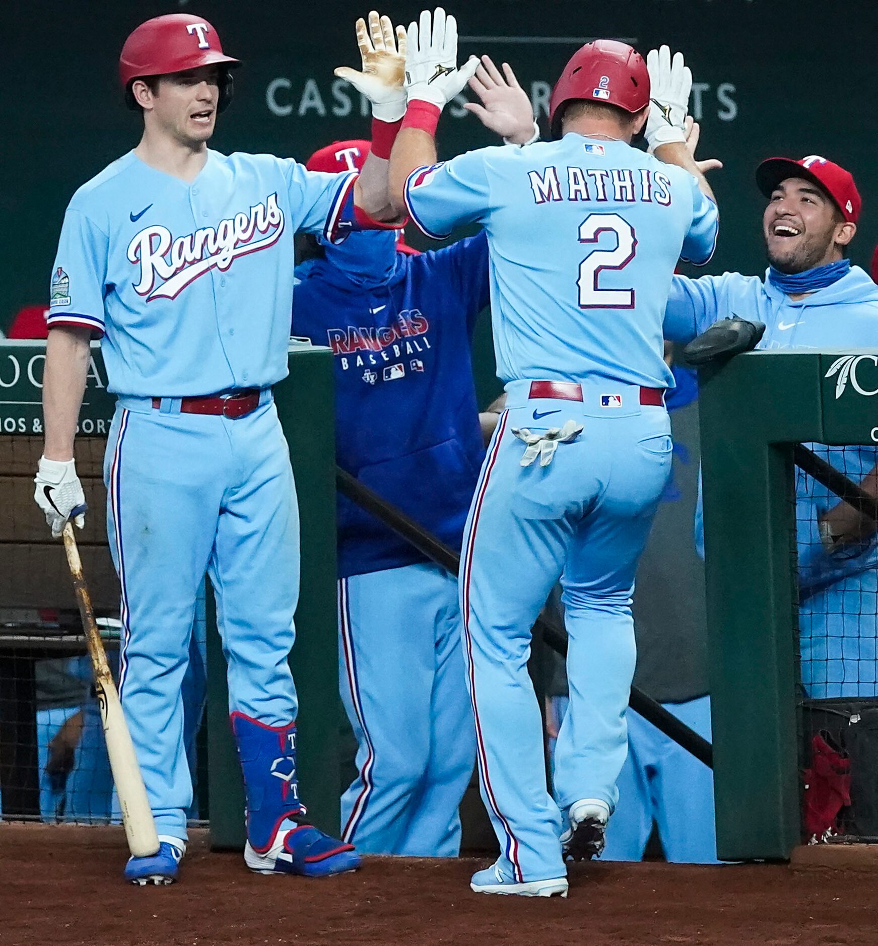 Texas Rangers catcher Jeff Mathis is welcomed back to the dugout by left fielder Nick Solak...