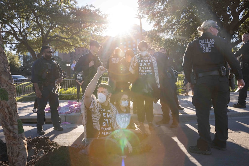 William Capper, with Jewish Voice for Peace, raises his fist as police detain protestors in...