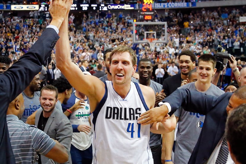 Dallas Mavericks forward Dirk Nowitzki (41) is congratulated by the team after surpassing...