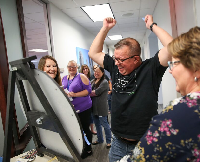 Will Hall, center, wins a prize during a National Payroll Week lunch celebration at...