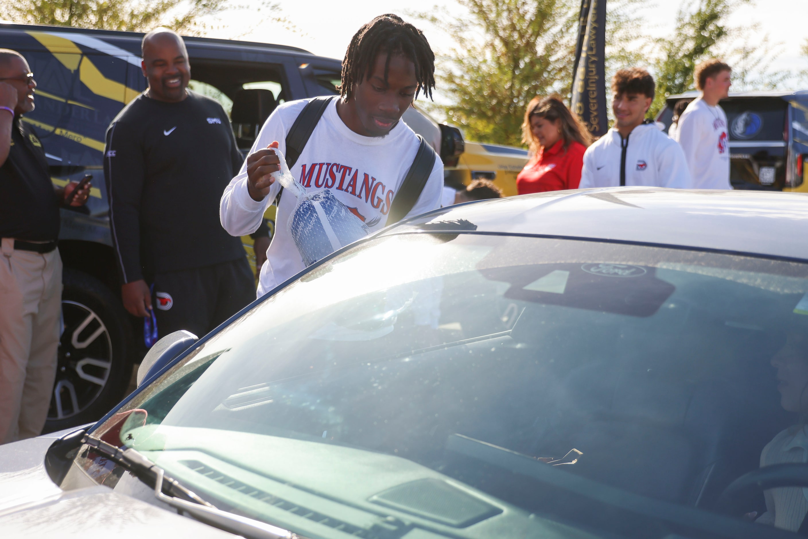 Southern Methodist University QB Kevin Jennings hands out a turkey on, Wednesday, Nov. 27,...