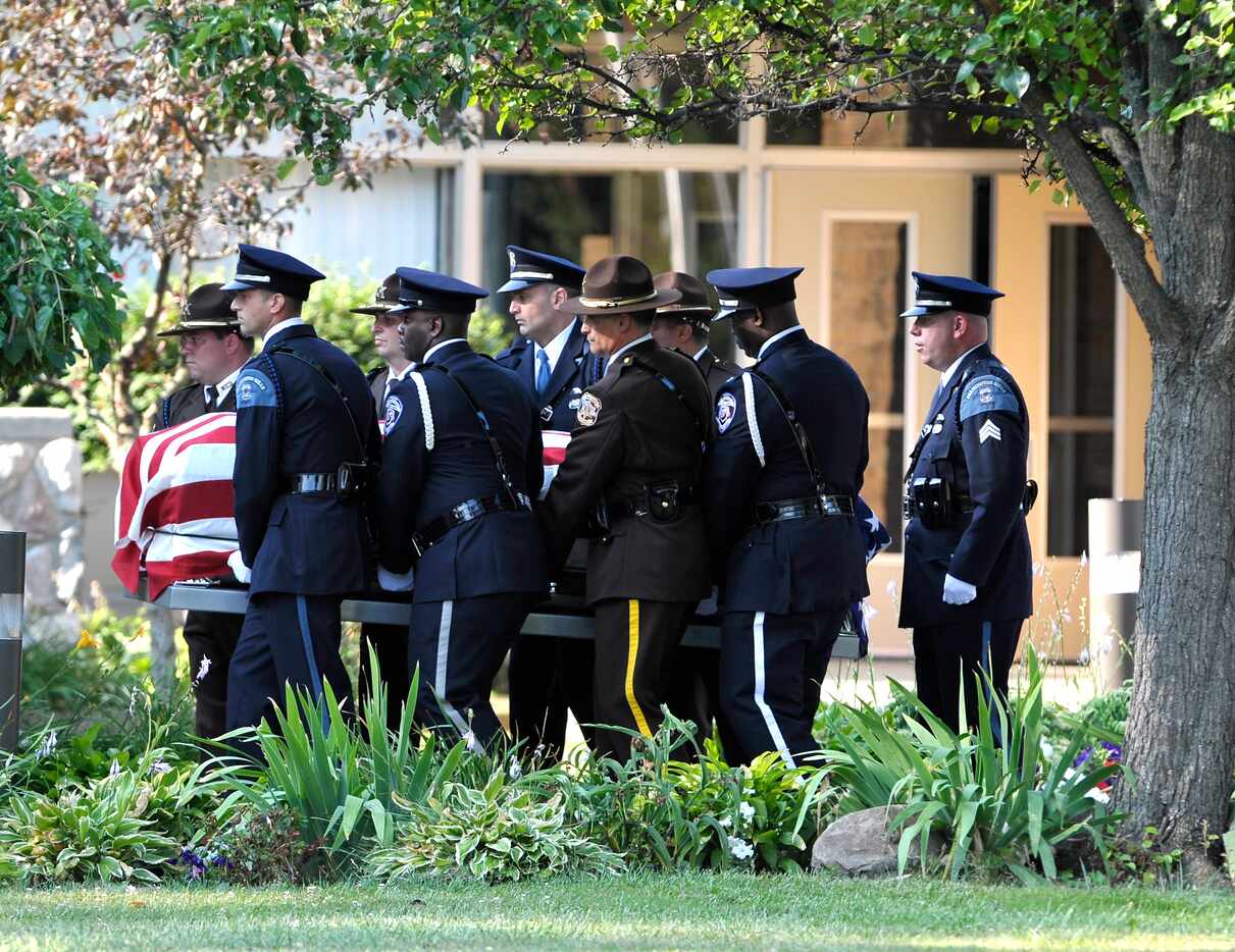 Pallbearers from various law enforcement departments carried the casket of Dallas police...