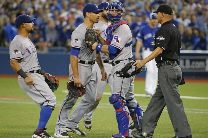 Texas Rangers relief pitcher Keone Kela, center, is restrained by catcher Chris Gimenez...