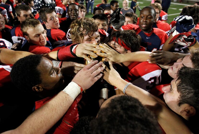 Allen celebrates with the 5A Division 1 Region II Finals Champion trophy over to his team...