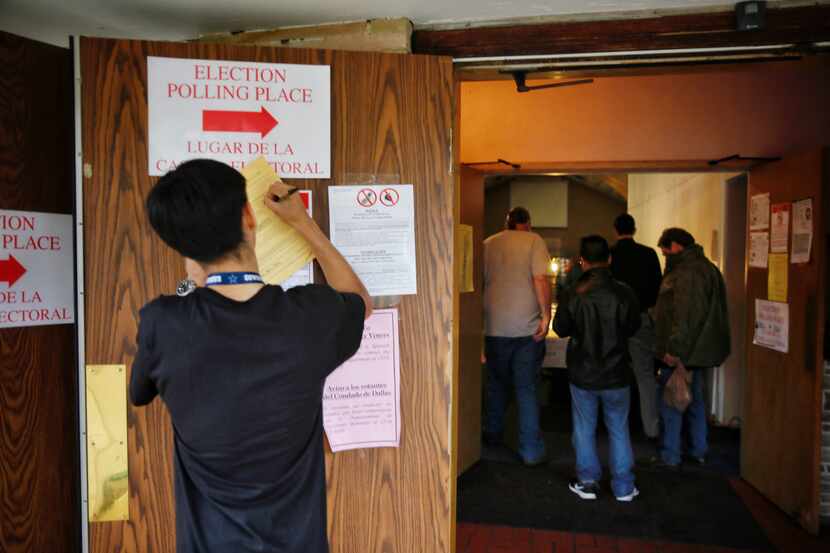 Elias Luevano, a student volunteer from Skyline High School, fills out paperwork as people...