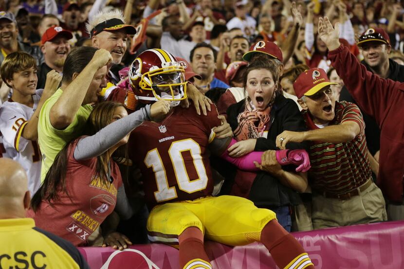 Washington Redskins quarterback Robert Griffin III (10) celebrates with the fans after a...