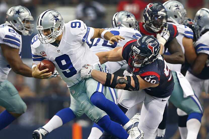 Dallas Cowboys quarterback Tony Romo (9) makes a nice escape moves on Houston Texans...