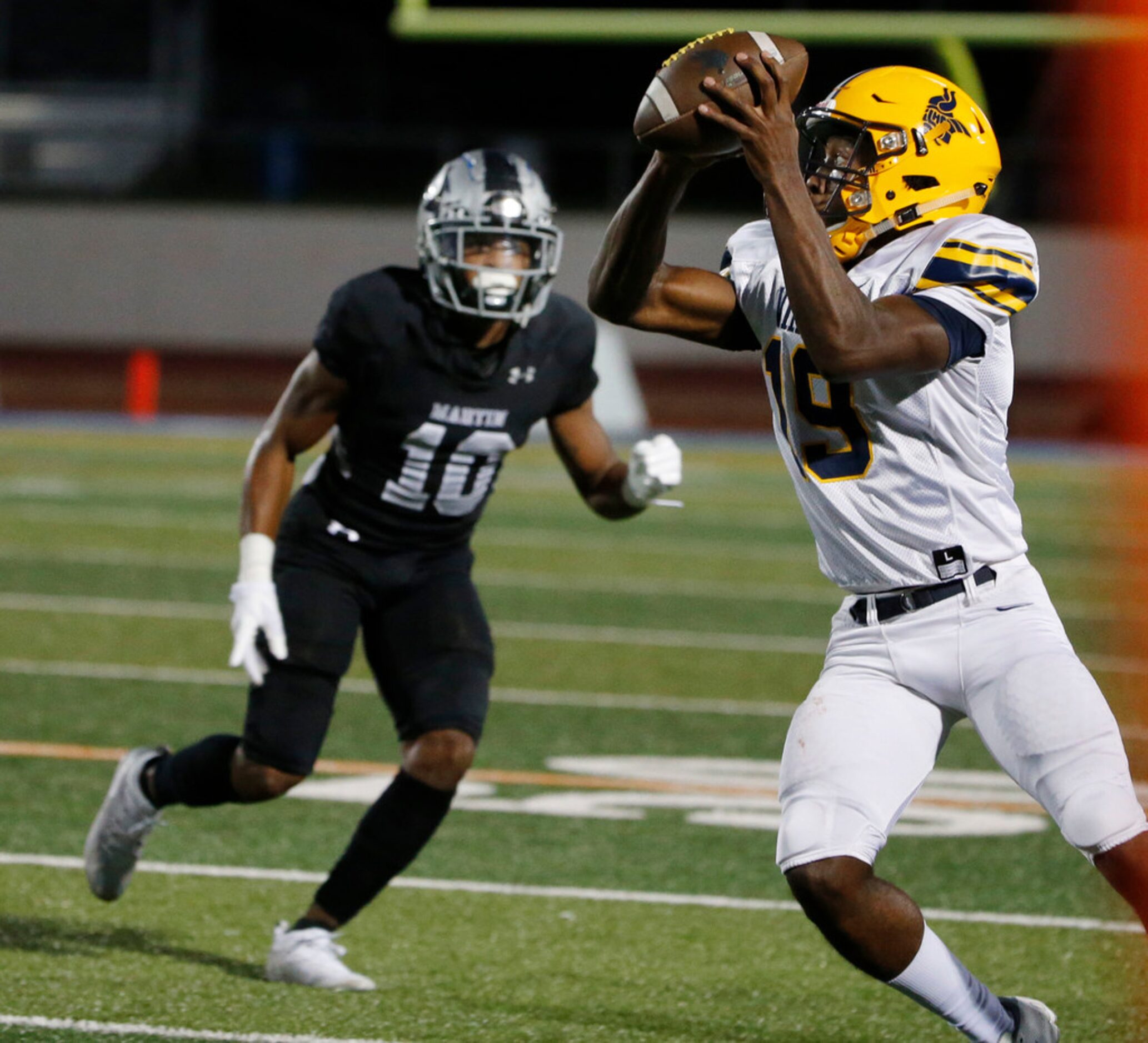 Arlington Lamar's Trevon West (19) catches a pass in front of Arlington Martin defender...