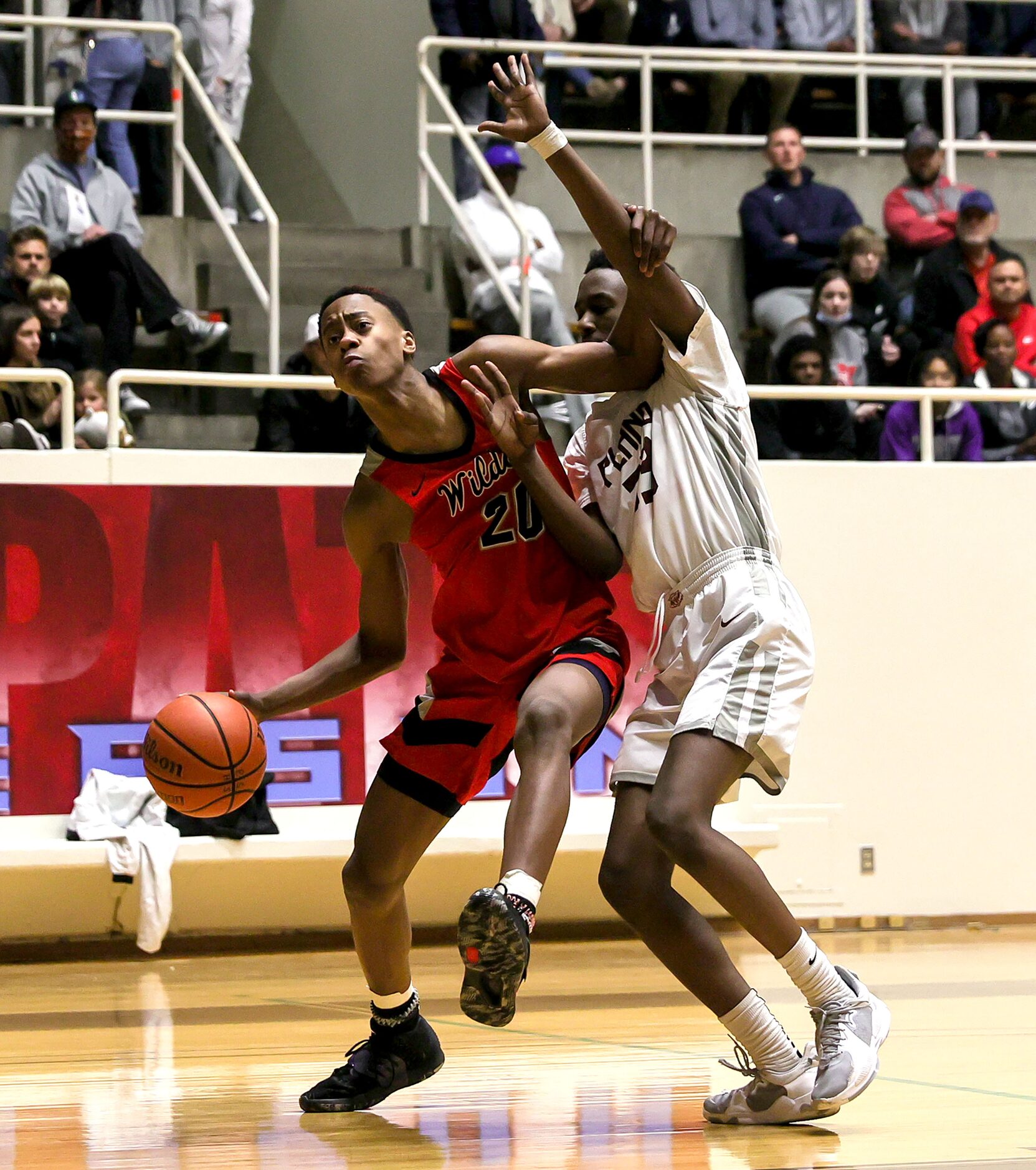 Lake Highland guard Tre Johnson (20) tries to dribble around Plano forward Rashon Mller (R)...