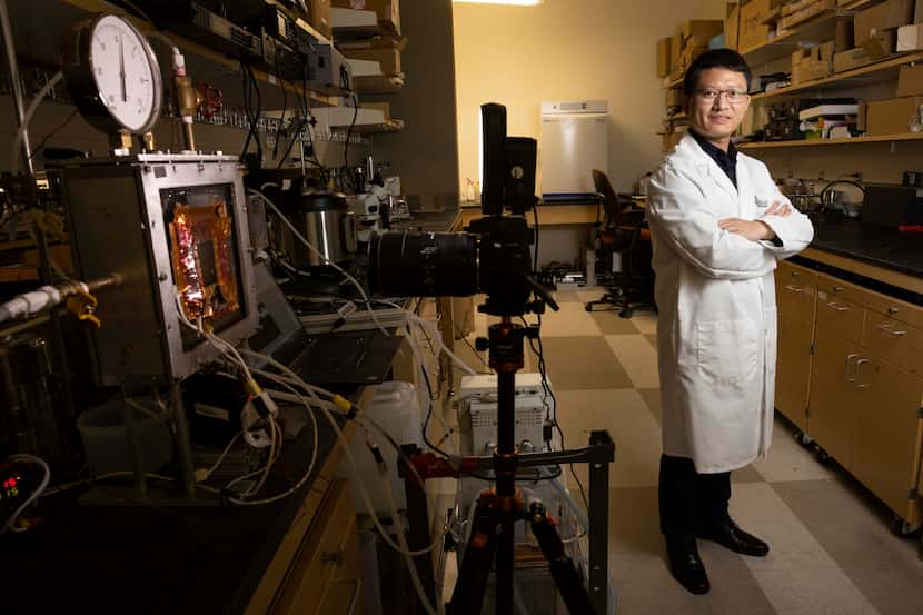 Xianming "Simon" Dai poses for a photo next to a condensation chamber in his lab on Nov. 10...