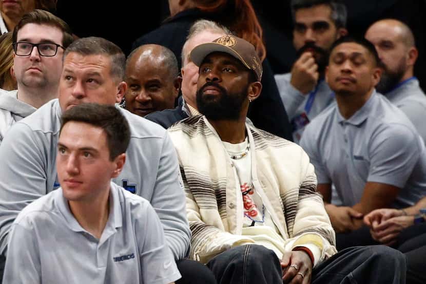 Dallas Mavericks guard Kyrie Irving (center left) watches the second half of an NBA game...