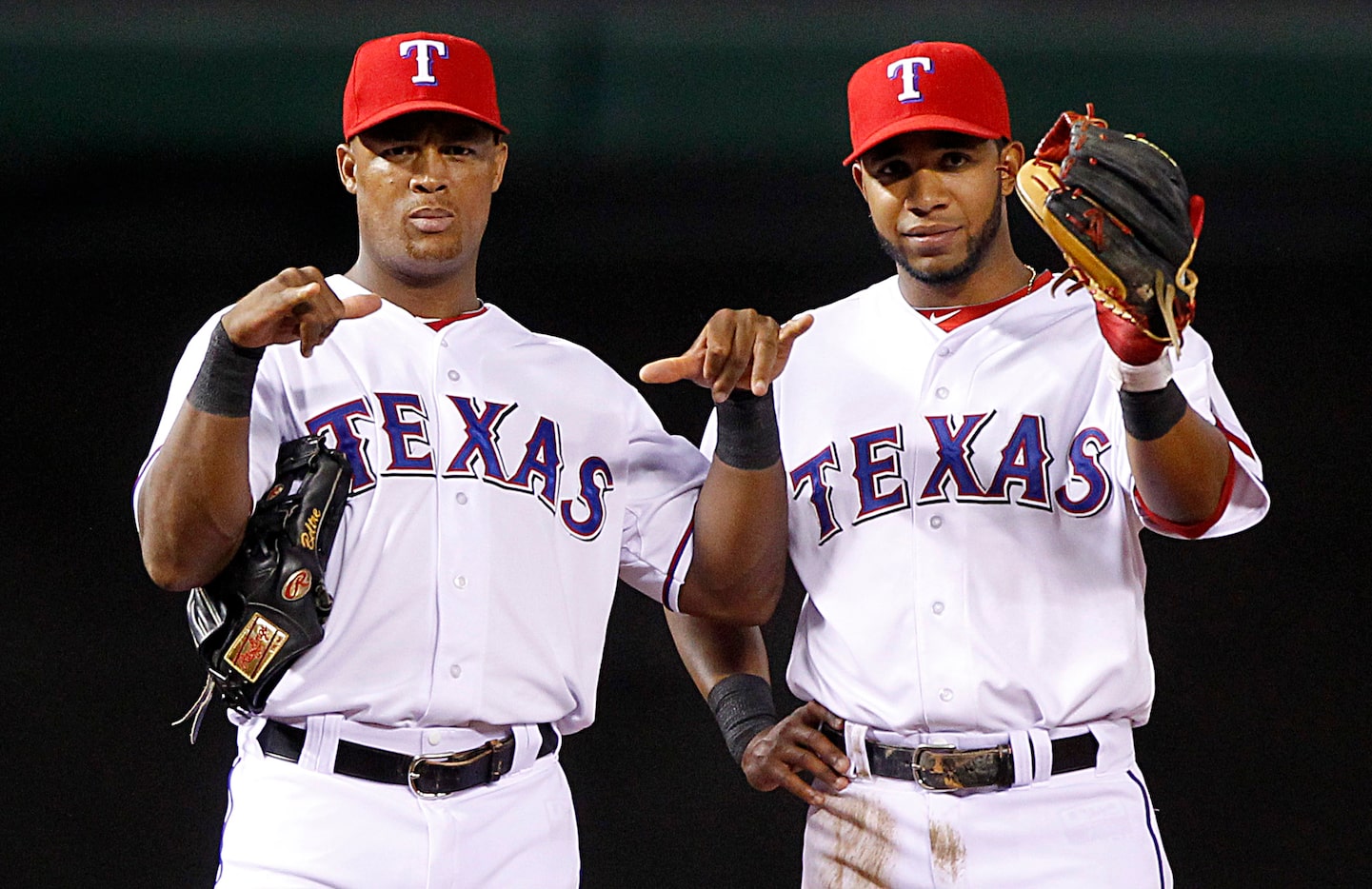 Texas Rangers third baseman Adrian Beltre, left, and shortstop Elvis Andrus (1) flash...