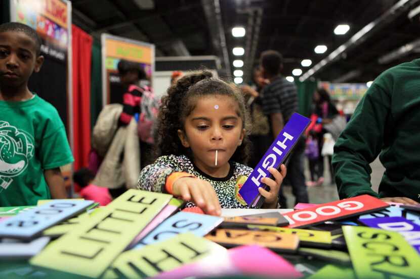 Nadia Burch, 3, browses through a collection of words as she picks which words she will use...